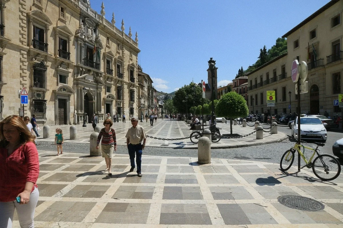 Plaza Nueva in central Granada with buildings and passers-by, Spain